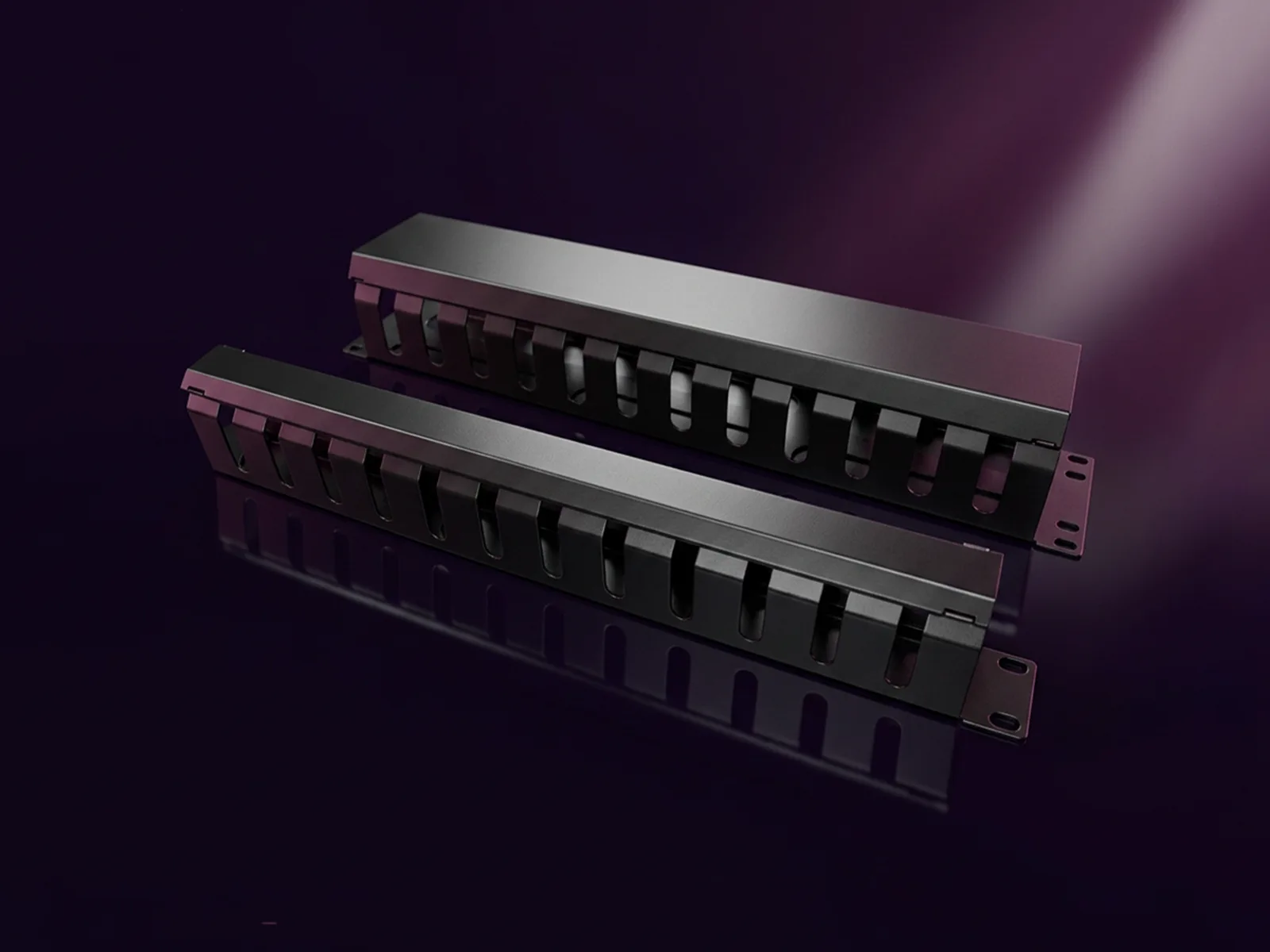 Two brushed-metal horizontal cable managers with finger-duct fronts, reflected on a dark surface.